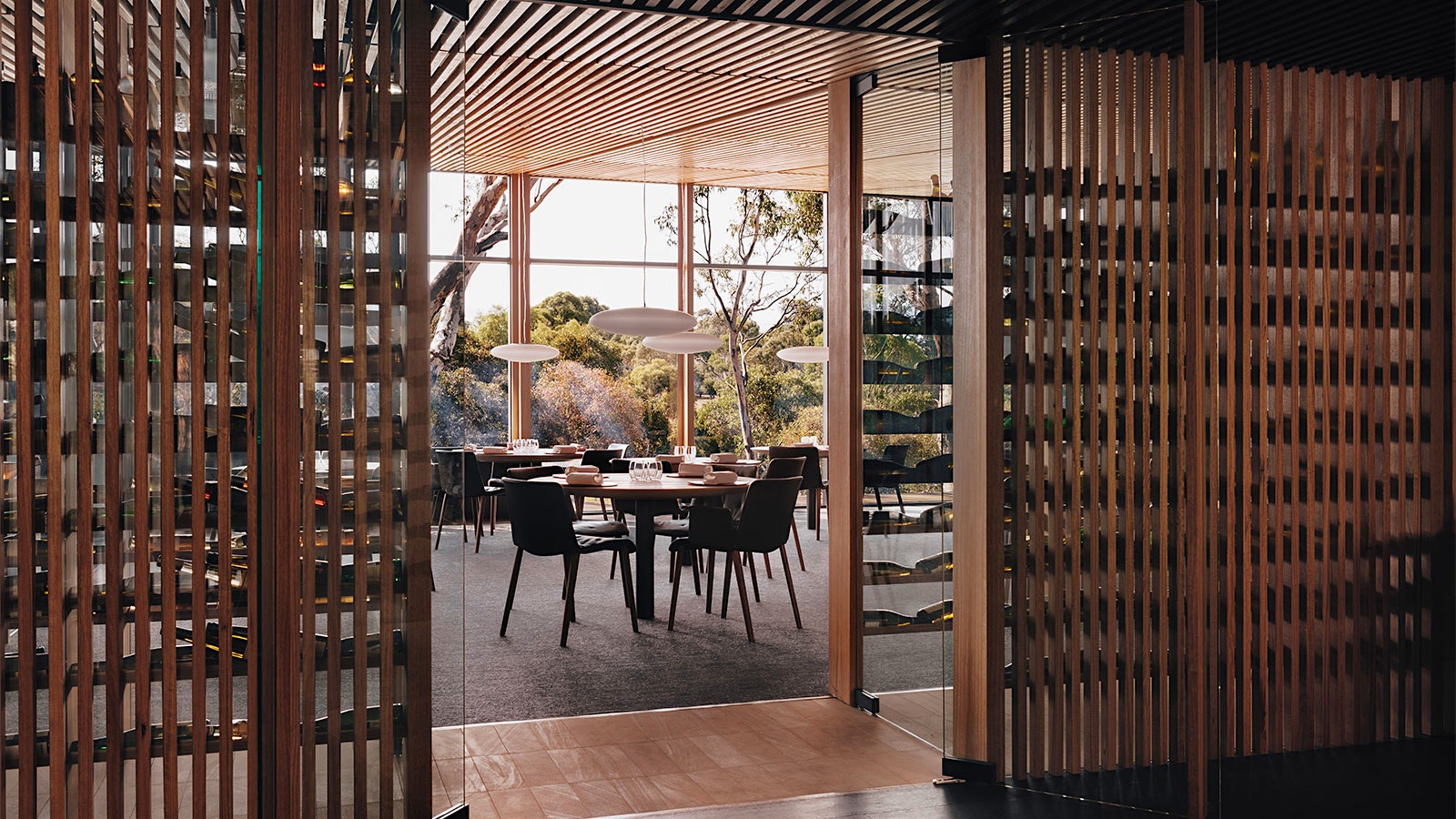 Bottles on wood racks leading into the dining room at Wickens at the Royal Mail Hotel